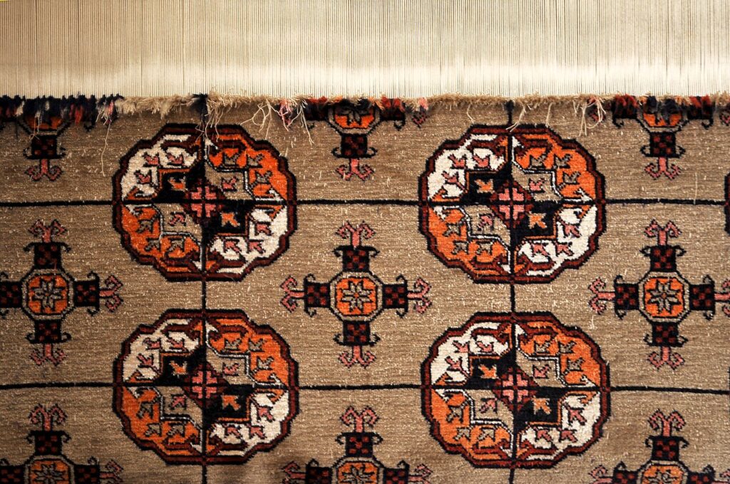 A half-finished hand-knotted rug on the loom in an artisanal carpet workshop in Samarkand, Uzbekistan